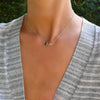 Woman wearing a Grand 14k yellow gold 1.17 mm cable chain necklace featuring two 6 mm briolette cut bezel set gemstones