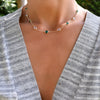 Woman wearing a Grand 14k yellow gold 1.17 mm cable chain necklace featuring nine 6 mm briolette cut bezel set gemstones