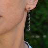 Woman wearing a Personalized Classic dangle earring featuring seven gemstones bezel set in 14k yellow gold