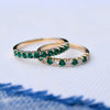 Pair of Rosecliff stackable rings featuring round cut emeralds, one with alternating diamonds, prong set in 14k yellow gold