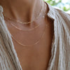 Woman wearing layered necklaces including a 14k gold Adelaide mini necklace featuring 8.4 x 3 mm paperclip chain links