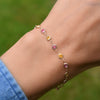 Woman with a 14k gold Sunset Newport bracelet featuring alternating 4 mm briolette cut pink tourmalines and citrines