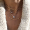 Woman with layered necklaces including a Rosecliff bar necklace with eleven 2 mm white topaz prong set in solid 14k gold