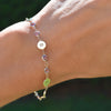 Wrist wearing a Newport gold bracelet featuring 4 mm gemstones and 1/4” flat letter-engraved discs
