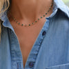 Woman wearing a Newport necklace featuring 4 mm briolette cut emeralds bezel set in 14k yellow gold