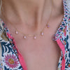 Woman wearing a Providence 5 Pink Tourmaline drop necklace with petite baguette cut stones set in 14k yellow gold