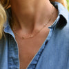 Woman wearing a Classic Birthstone 1.17 mm cable chain necklace featuring 4 mm briolette cut gemstones in 14k yellow gold