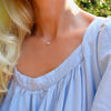 Woman wearing a Grand 14k yellow gold cable chain necklace featuring a 6 mm briolette cut bezel set pink opal